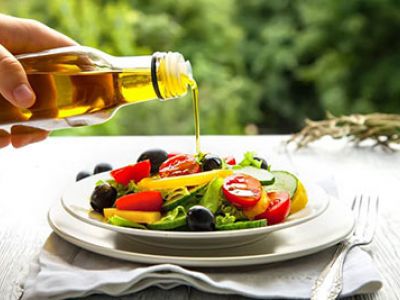 oil being poured onto a salad.